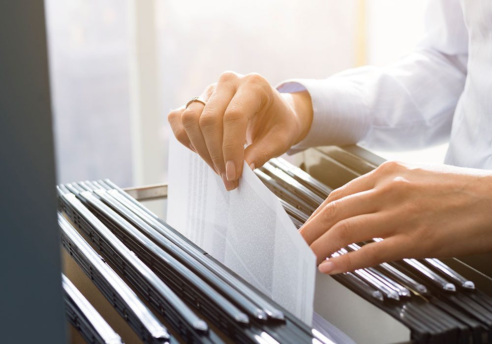 Office clerks hand filing document
